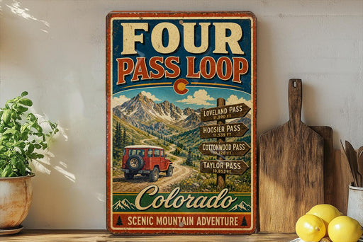 A vintage-style metal sign advertising the Four Pass Loop in Colorado, featuring a red jeep and mountain scenery.