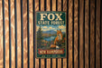 A vintage metal sign for Fox State Forest in New Hampshire, featuring an illustration of a fox in a forest setting.