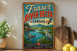 A vintage-style sign for Fraser River Delta, Canada, featuring a scenic illustration of a river, mountains, and wildlife.