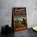 A vintage metal sign advertising the Freedom's Frontier National Heritage Area in Kansas, featuring an illustration of a wagon and a steamboat.