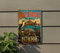 A vintage-style metal sign with the text "GALAPAGOS ISLANDS" and "ECUADOR" is displayed on a wall, featuring illustrations of various animals and landscapes.