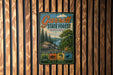 A vintage metal sign for Garrett State Forest in Maryland, featuring a scenic landscape with pine trees, a river, and mountains.