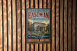 A vintage-style metal sign for the George Eastman Museum in Rochester, New York, featuring an illustration of a building surrounded by trees.