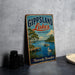 A vintage-style metal sign for Gippsland Lakes, Australia, featuring a scenic illustration of a lake, a pier, and a bird.