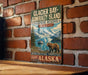 A vintage-style metal sign for Glacier Bay-Admiralty Island, Alaska, featuring a scenic image of a bear and a boat on a river surrounded by mountains.