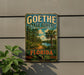 A vintage-style metal sign for Goethe State Forest in Florida, featuring a scenic landscape with palm trees and a river.