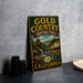 A vintage-style metal sign for the Gold Country Heritage Trail in California, featuring an illustration of a scenic landscape with a waterfall and buildings.