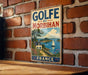 A vintage-style metal sign with the text "GOLFÉ DU MORBIHAN FRANCE" is displayed on a brick wall.