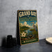 A vintage-style metal sign for the Grand Bay National Estuarine Research Reserve in Mississippi, featuring an illustration of a bird, flowers, and a body of water.