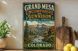 A vintage-style sign for Grand Mesa, Uncompahgre, and Gunnison National Forests in Colorado, featuring a scenic mountain landscape.