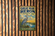 A vintage-style sign for Great Blue Heron Provincial Park in Saskatchewan, featuring a heron standing in a grassy area with a lake in the background.
