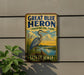 A vintage-style sign for Great Blue Heron Provincial Park in Saskatchewan, Canada, featuring an illustration of a heron standing on a grassy bank with a body of water in the background.