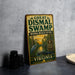 A vintage-style metal sign for the Great Dismal Swamp National Wildlife Refuge in Virginia, featuring an illustration of a bird and a swamp environment.
