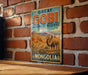 A vintage-style metal sign with the text "GREAT GOBI BIOSPHERE RESERVE MONGOLIA" is displayed on a brick wall.