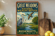 A framed vintage-style poster advertising the Great Meadows National Wildlife Refuge in Massachusetts, featuring illustrations of birds and a scenic landscape.
