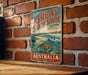 A vintage-style sign for the Great Sandy Strait in Australia, featuring a scenic illustration of the strait with a turtle and boats.