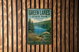 A vintage-style metal sign for Green Lakes State Park in New York, featuring a scenic image of the lake surrounded by trees and mountains.