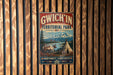 A vintage-style metal sign with the text "GWICH'IN TERRITORIAL PARK" and a depiction of a tent and reindeer in a mountainous landscape.