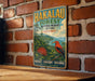 A vintage-style metal sign for the Hakaau Forest National Wildlife Refuge in Hawaii, featuring a red bird and tropical foliage, is displayed on a brick wall.