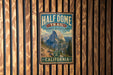 A vintage-style metal sign for the Half Dome Trail in Yosemite National Park, California, featuring a scenic mountain landscape.