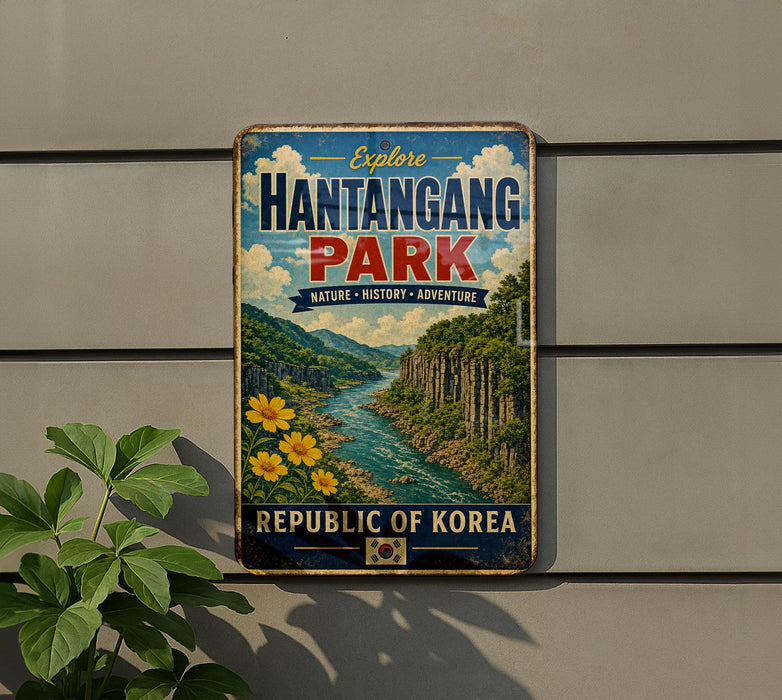 a vintage-style metal sign with a scenic illustration of a river and mountains, mounted on a wall.