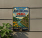 a vintage-style metal sign with a scenic illustration of a river and mountains, mounted on a wall.