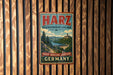 A vintage metal sign with the text "HARZ BRAUSWEGER LAND PARK NATUR-ERHOLING-ABENTEUER GERMANY" hanging on a wooden wall.