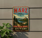 A vintage metal sign for Harz, Braunswinger Land Park, Germany, featuring a scenic landscape with mountains, a river, and a castle.
