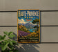 A vintage metal sign for Haute-Provence Park in France, featuring a scenic landscape with mountains, fields, and a river.