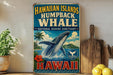 A vintage-style sign advertising the Hawaiian Islands humpback whale, with a picture of a humpback whale and tropical scenery.