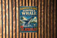 A vintage-style metal sign for the Hawaiian Islands humpback whale, featuring a whale leaping out of the water and the text "Hawaii humpback whale" and "National Marine Sanctuary".