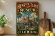 A vintage-style sign for the Henry B. Plant Museum in Florida, featuring a colorful illustration of the museum's architecture and surrounded by tropical plants.