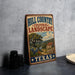 A vintage-style metal sign advertising "Hill Country Cultural Landscape" in Texas, featuring a scenic landscape with a tree, house, and mountains.