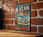 A vintage-style metal sign with the text "Historic and Architectural Complex of the Kazan Kremlin Russia" is displayed on a brick wall.