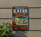 A vintage-style poster advertising the Kazan Kremlin in Russia, featuring a colorful illustration of the historic complex and its iconic landmarks.