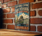 A vintage-style metal sign displaying the name of the historic center of Saint Petersburg, Russia, with an illustration of the city's landmarks.