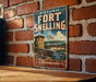 A vintage-style metal sign with the text "HISTORIC FORT SNELLING" and "MINNESOTA" printed on it, mounted on a brick wall.