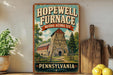 A vintage-style sign for the Hopewell Furnace National Historic Site in Pennsylvania, featuring an illustration of a stone building with a tower.