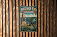 A vintage metal sign for Horseshoe Bend National Military Park in Alabama, featuring a cannon and a monument, mounted on a wooden wall.