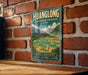 A vintage-style metal sign for the Huanglong Biosphere Reserve in China, featuring a scenic landscape with mountains, waterfalls, and traditional Chinese architecture.