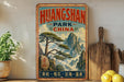 A vintage-style poster advertising Huangshan Park in China, featuring a scenic mountain landscape with a pine tree.
