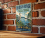 A vintage-style sign for the Hudson River National Estuarine Research Reserve, featuring a heron and a sailboat on a body of water.