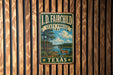 A vintage metal sign for the I.D. Fairchild State Forest in Texas, featuring a scenic illustration of a forest landscape with a deer.