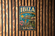 A vintage metal sign with the text "IBiza Biodiversity & Culture" and "Spain" on it, hanging on a wooden wall.