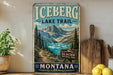A vintage-style sign for the Glacier National Park Lake Trail in Montana, featuring a scenic mountain landscape with a lake in the background.