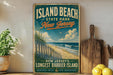 A vintage-style sign for Island Beach State Park in New Jersey, featuring a beach scene with a wooden fence and a bird in flight.