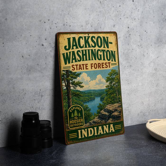 A vintage-style metal sign for Jackson-Washington State Forest, Indiana, featuring a scenic landscape with a river and trees.