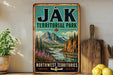 A vintage-style metal sign for "Jak Territorial Park" in Northwest Territories, featuring a scenic mountain landscape with a river and pine trees.