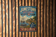 A vintage-style metal sign for Jamestown Settlement, Virginia, featuring a ship and a scene from the settlement.