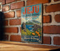A vintage-style metal sign for Jeju Island Park, the Republic of Korea, featuring a scenic landscape with mountains, a statue, and orange trees.